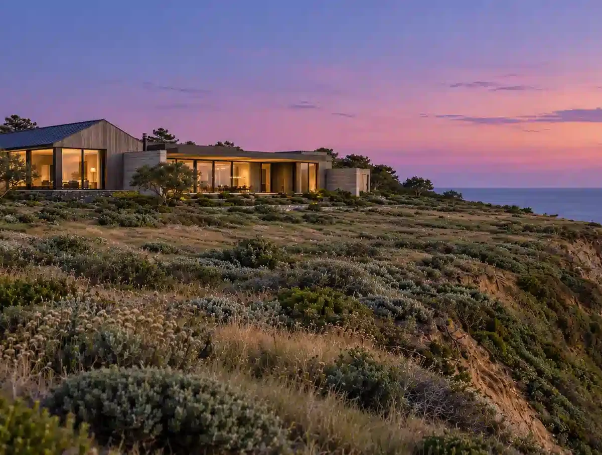 Rendering of a modern estate as a Malibu architect might draw it, set back on a Pacific bluff at dusk, warm light inside